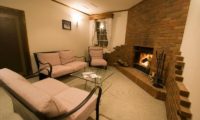 Snowgum Lodge Seating Area near Fireplace | East Hirafu