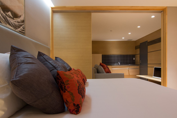 Koharu Resort Hotel and Suites One Bedroom Apartment Bedroom with Sofa and Kitchen | Upper Wadano