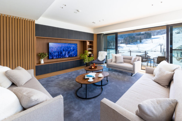 Roka five bedroom penthouse living room suite with coffee table, white sofas, flat-screen TV, panorama ski slope views | Happo Village, Hakuba