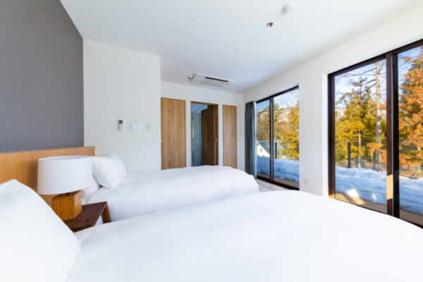 Roka five bedroom penthouse bedroom with twin beds, balcony and forest views | Happo Village, Hakuba
