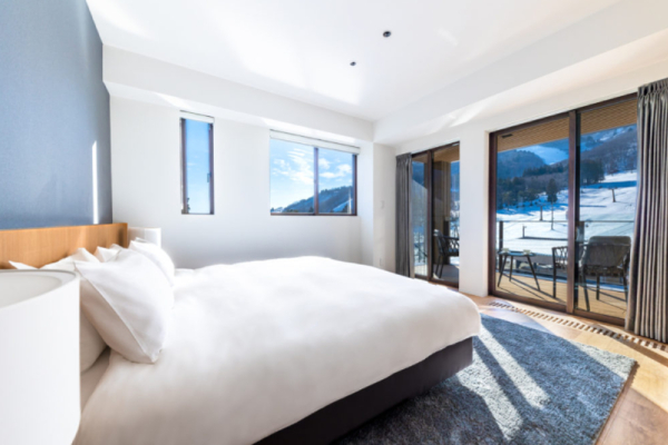 Roka five bedroom penthouse bedroom double bed with terrace deck chairs, ski slope view | Happo Village, Hakuba