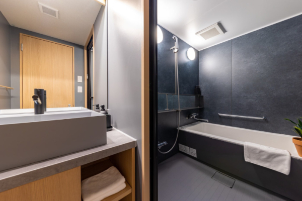 The Happo family hotel room en suite bathroom with bathtub, separate shower and washstand | Happo Village, Hakuba