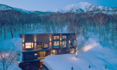 Song Saa exterior evening whole chalet front view with heated driveway, entrance, full height windows and exterior lighting, Mt Annupuri in the background | Annupuri, Niseko